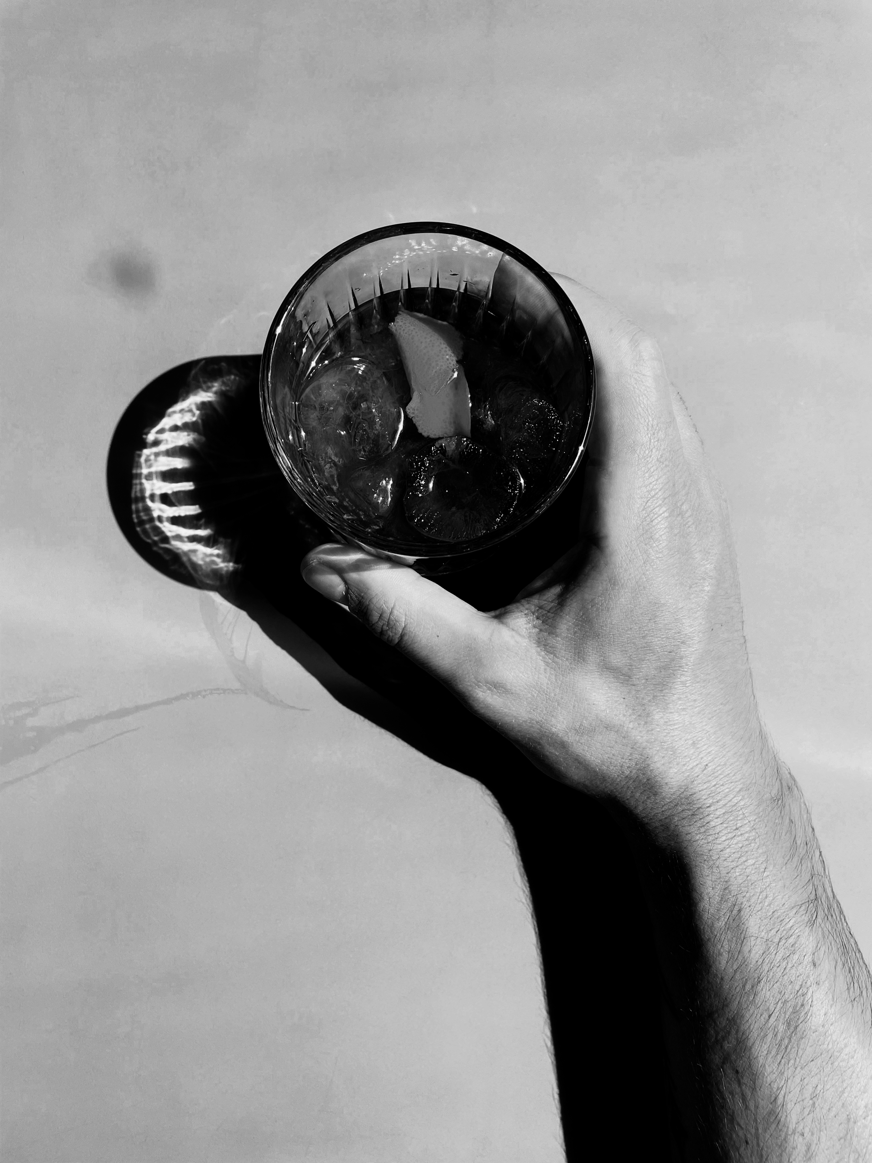 Black and white phot of a hand holding a glass.